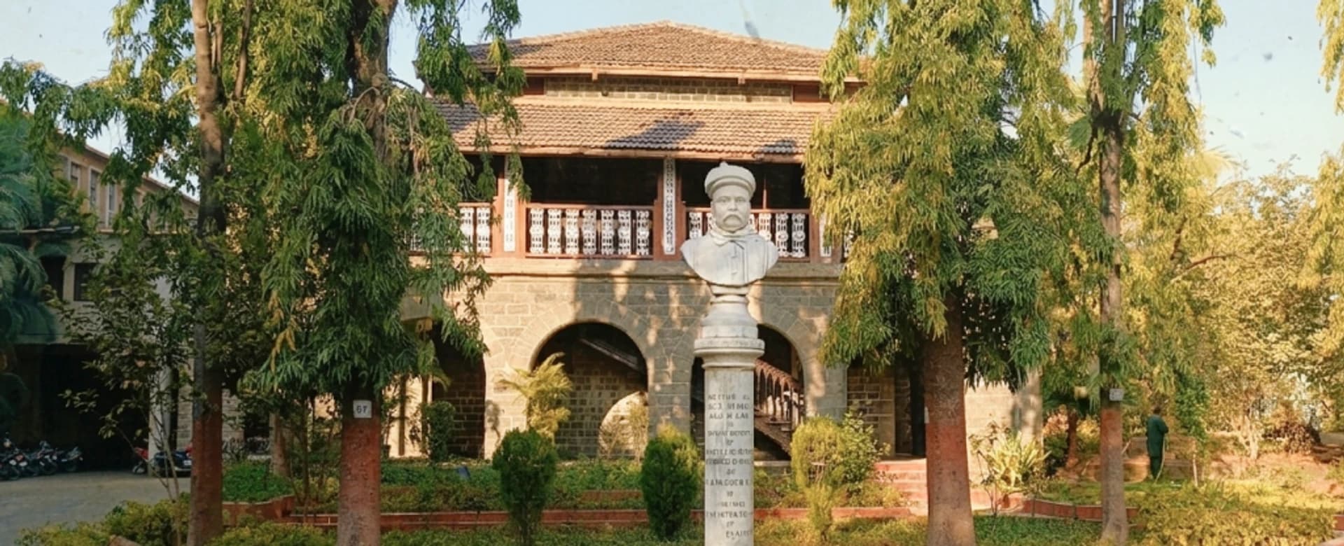 Gokhale Institute campus with historic building and memorial bust